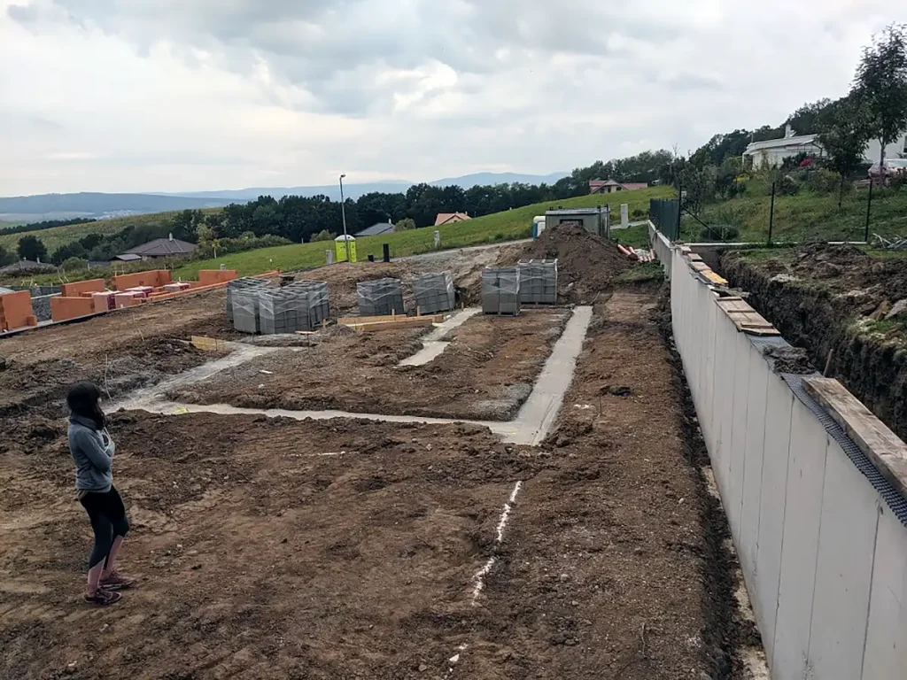 Vyrovnanie pozemku s oporným múrom a prvou betonávkou základov